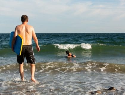 Surfer Walking to the Water at a Beach in Marblehead MA