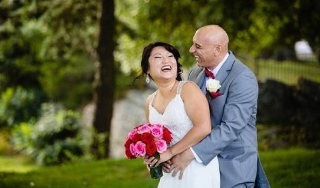 A couple happily posing with each other on their wedding day.