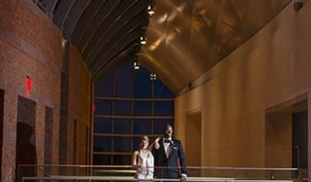 A bride and groom posing inside the Peabody Essex Museum in Salem, Massachusetts