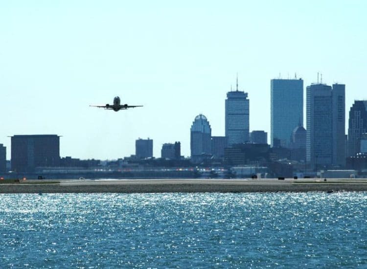 A plane taking off with Boston skyline in the background